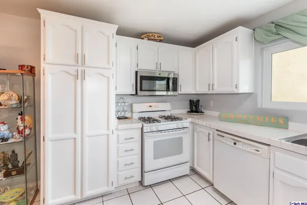 a kitchen with white cabinets and white appliances