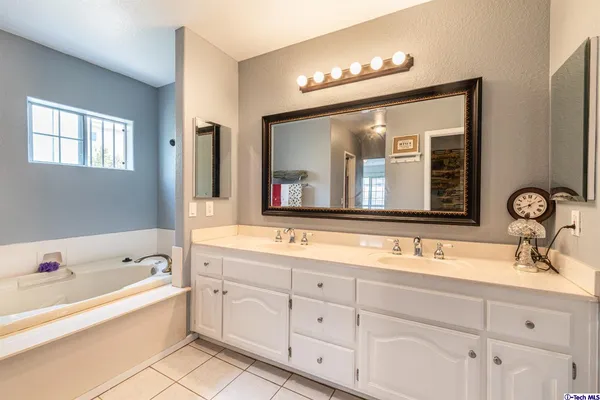 a bathroom with a granite countertop sink mirror and bathtub