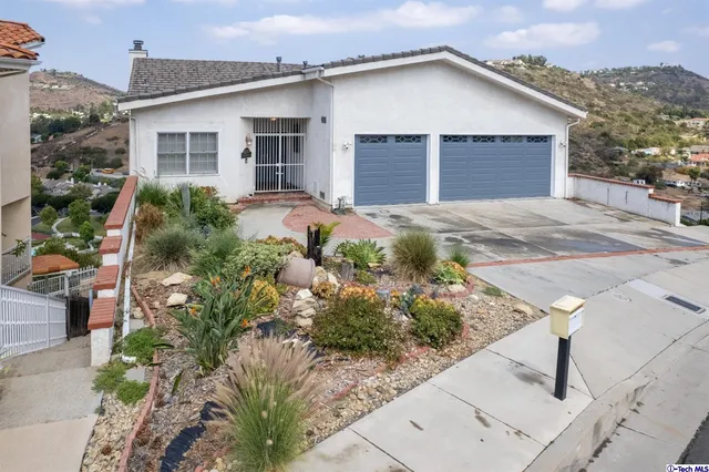 a view of a house with yard and potted plants