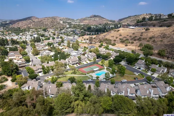 an aerial view of residential houses with outdoor space and trees