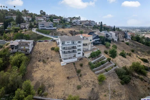an aerial view of a house with a yard and lake view in back