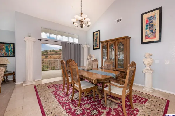 a view of a dining room with furniture a rug and wooden floor