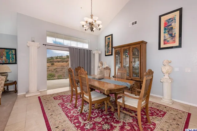 a view of a dining room with furniture a rug and wooden floor