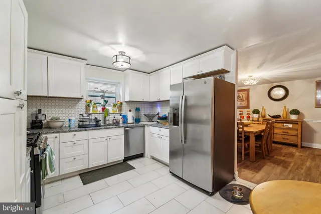 a kitchen with stainless steel appliances granite countertop a refrigerator a stove and a sink