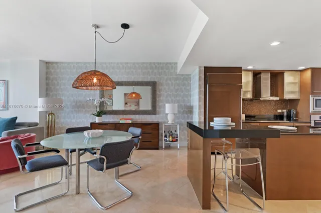 a kitchen with stainless steel appliances granite countertop a stove a sink a dining table and chairs