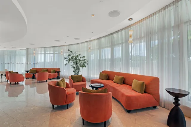 a living room with furniture and a large window with garden view