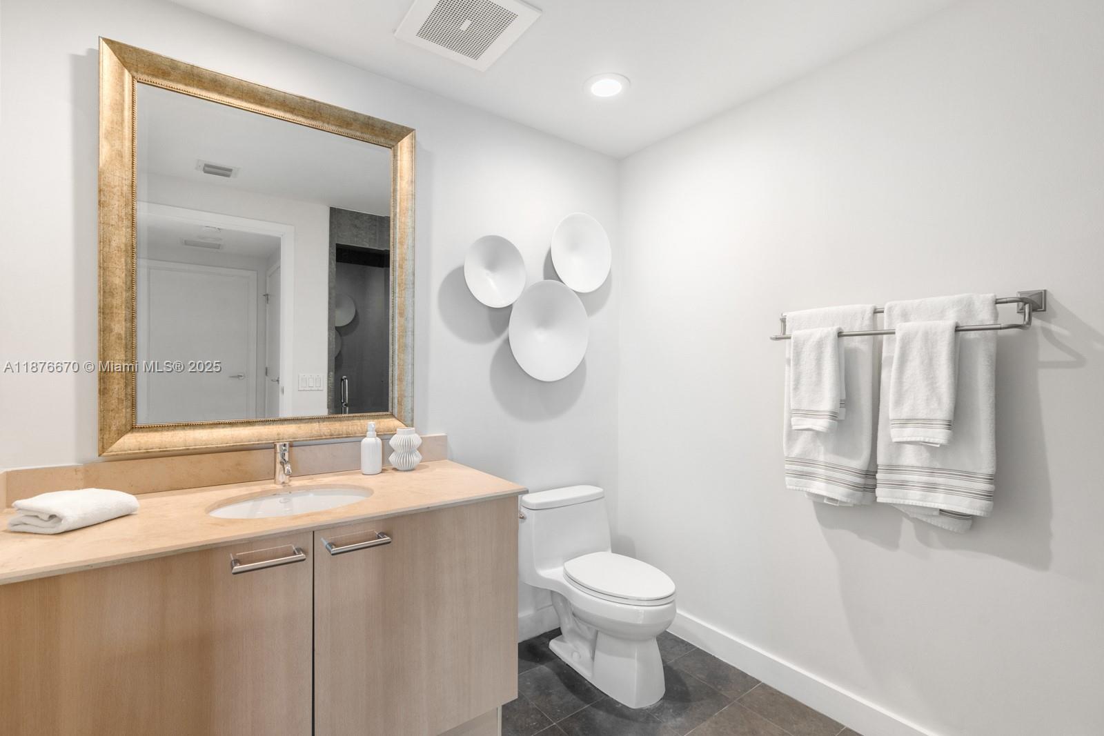 3801 Collins Avenue, Unit 503 Miami Beach, FL 33140 - Photo 9 of 31 a bathroom with a sink a toilet and a mirror