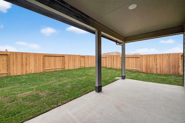 a view of a yard with wooden fence