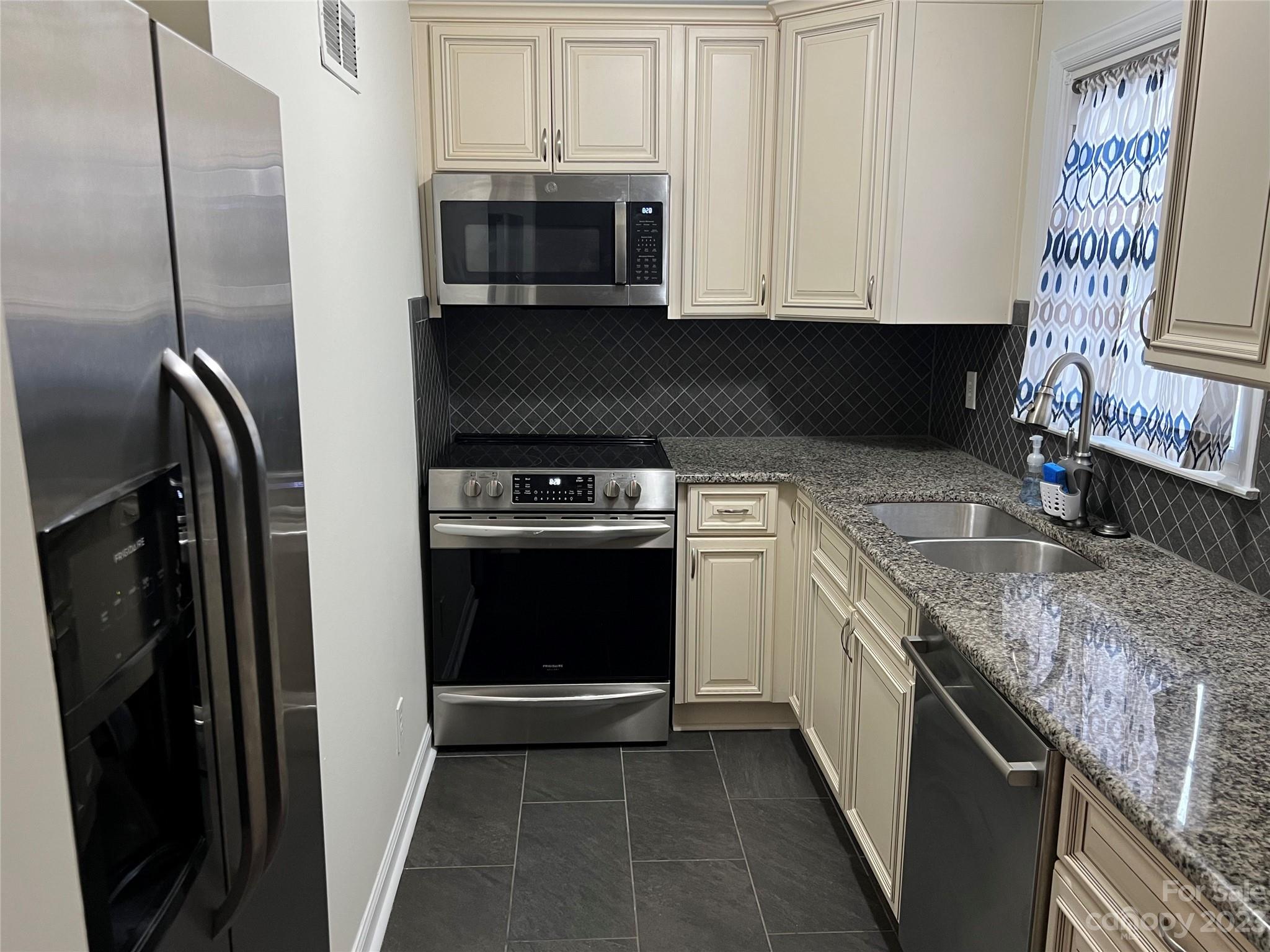 908 McAlway Road Charlotte, NC 28211 - Photo 8 of 13 a kitchen with stainless steel appliances granite countertop a stove a microwave and a refrigerator