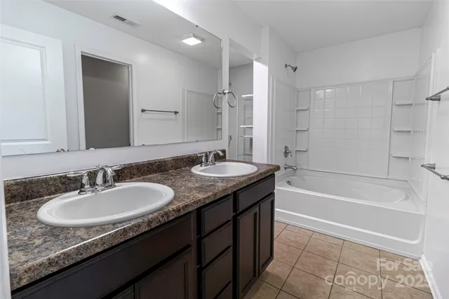a bathroom with a granite countertop sink tub and a mirror