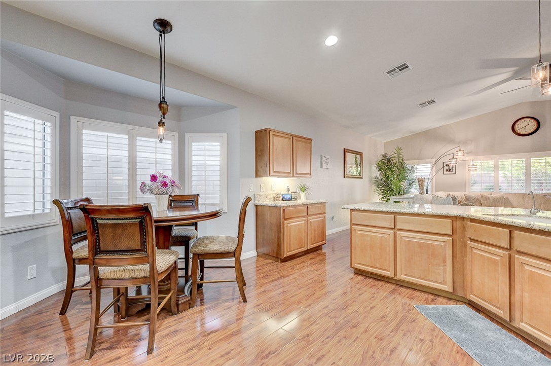 1604 Cattle Ranch Place Henderson, NV 89002 - Photo 99 of 99 An open floorplan seamlessly connects the kitchen and dining area, featuring hardwood floors and granite counters.