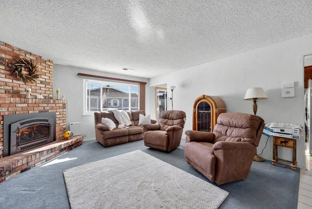 a living room with furniture a fireplace and a large window