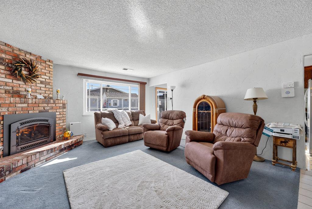 12932 Truman Street Salinas, CA 93906 - Photo 6 of 24 a living room with furniture a fireplace and a large window