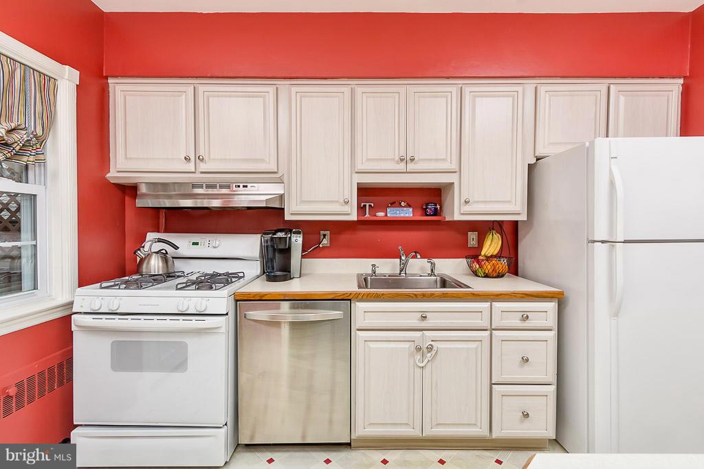 227 Dumbarton Road Baltimore, MD 21212 - Photo 12 of 30 a kitchen with stainless steel appliances granite countertop a refrigerator a stove and white cabinets with wooden floors