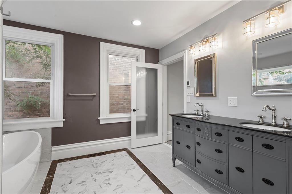 2217 Sarah Street Pittsburgh, PA 15203 - Photo 23 of 33 a spacious bathroom with double vanity and a mirror