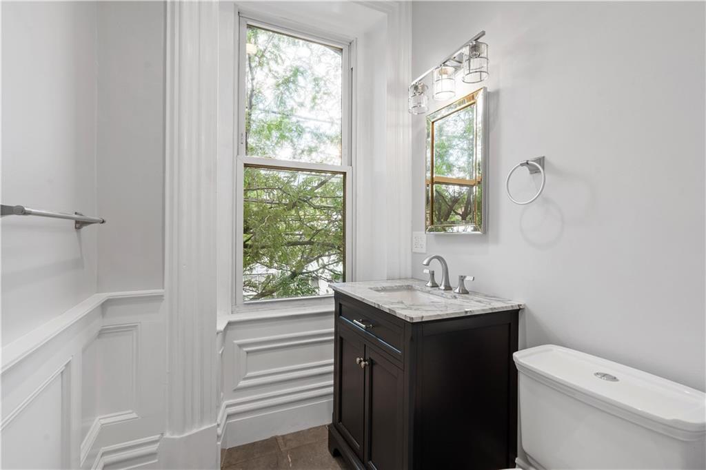 2217 Sarah Street Pittsburgh, PA 15203 - Photo 26 of 33 a bathroom with a granite countertop toilet a sink and a window