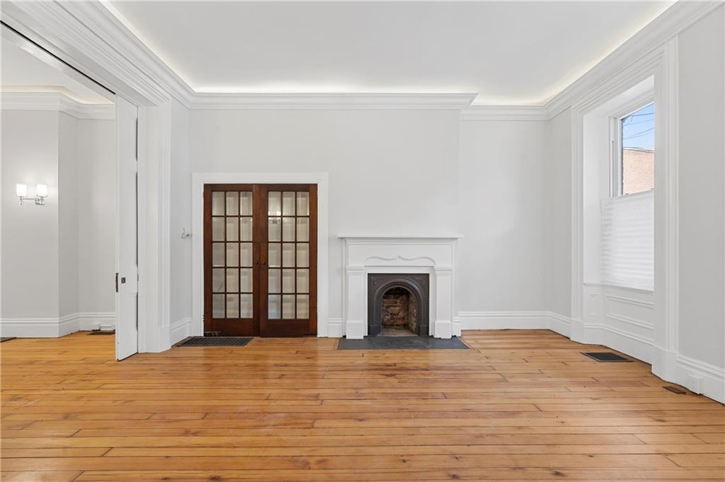 2217 Sarah Street Pittsburgh, PA 15203 - Photo 7 of 33 a view of empty room with wooden floor and fireplace