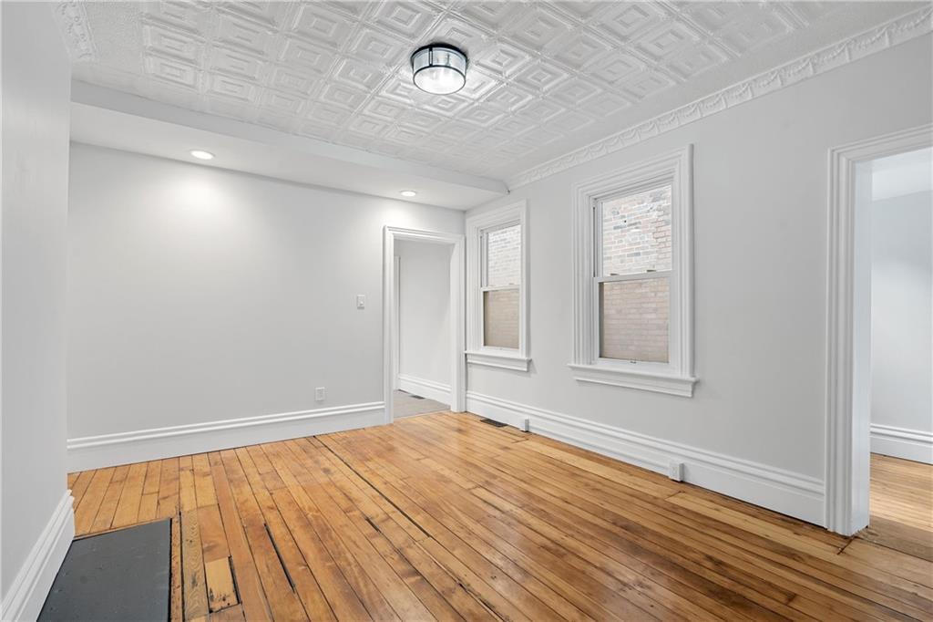 2217 Sarah Street Pittsburgh, PA 15203 - Photo 8 of 33 wooden floor in an empty room with a window