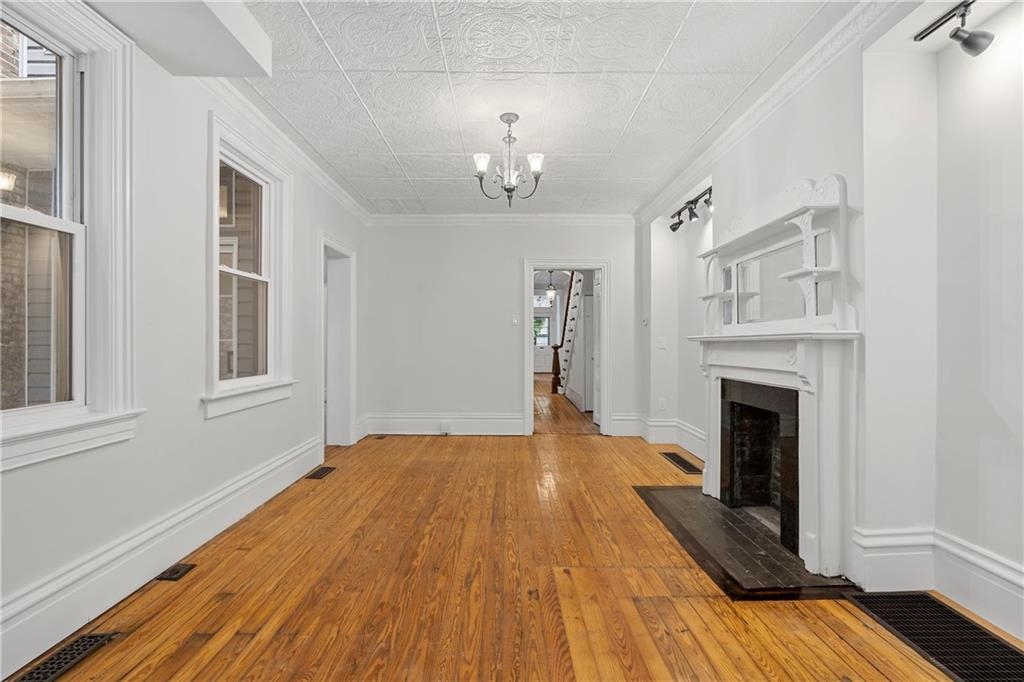 2217 Sarah Street Pittsburgh, PA 15203 - Photo 9 of 33 a view of an empty room with wooden floor fireplace and a window