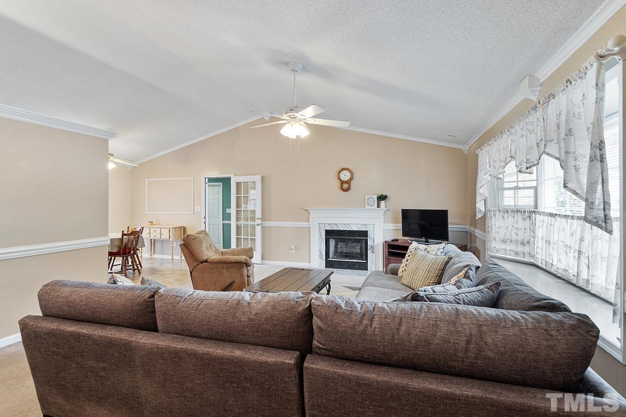 1406 Buckhorn Road Garner, NC 27529 - Photo 13 of 29 a living room with furniture fireplace and a flat screen tv