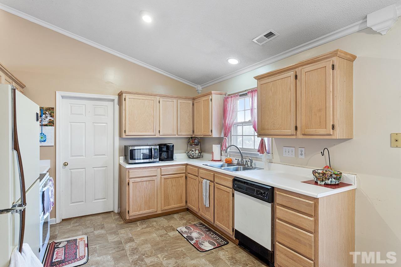 1406 Buckhorn Road Garner, NC 27529 - Photo 19 of 29 a kitchen with granite countertop a sink stainless steel appliances and cabinets