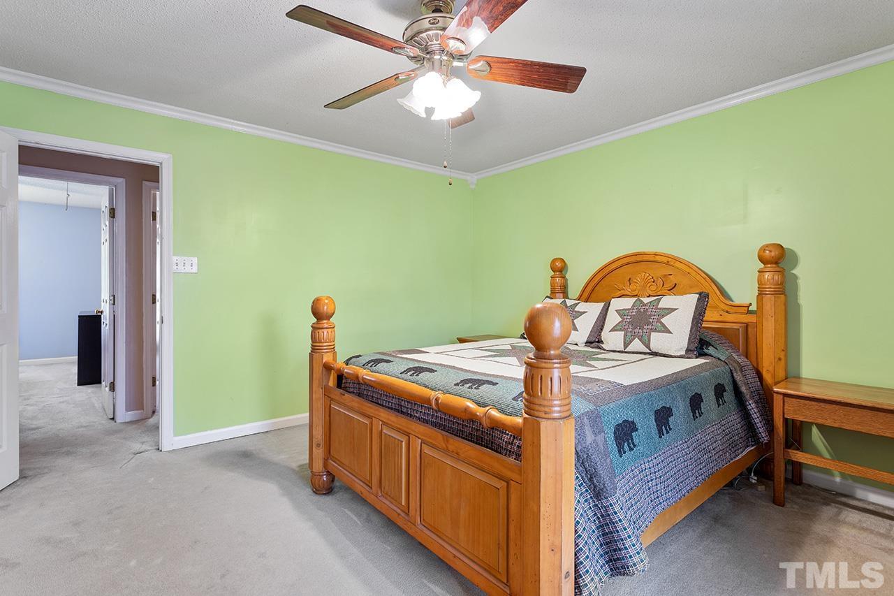 1406 Buckhorn Road Garner, NC 27529 - Photo 25 of 29 a bed room with a bed and a chandelier