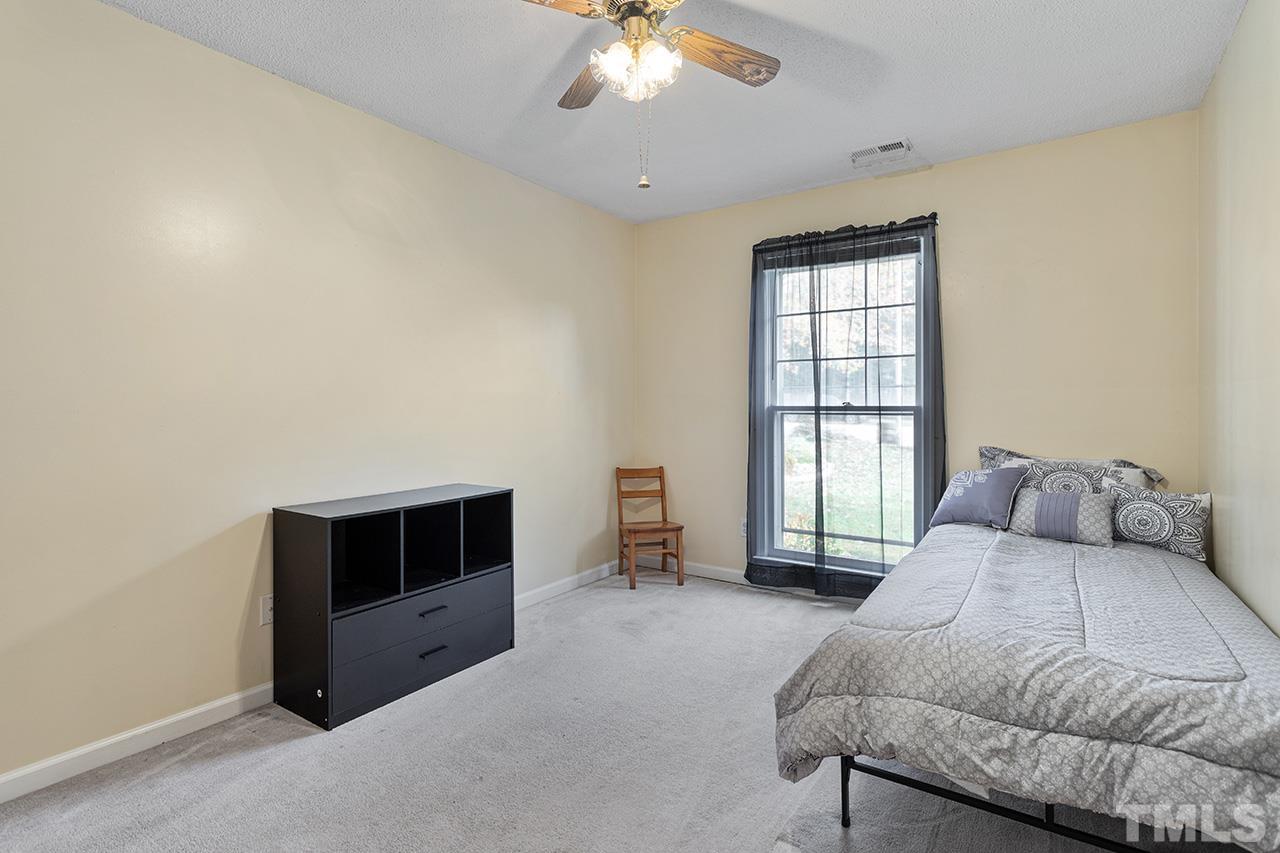 1406 Buckhorn Road Garner, NC 27529 - Photo 27 of 29 a spacious bedroom with a bed and a chandelier