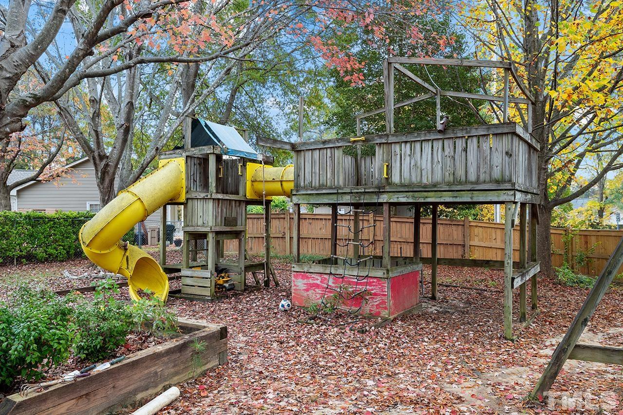 1406 Buckhorn Road Garner, NC 27529 - Photo 7 of 29 a view of a backyard with a tree and a wooden fence