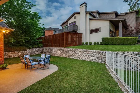 a view of a chair and table in backyard of the house