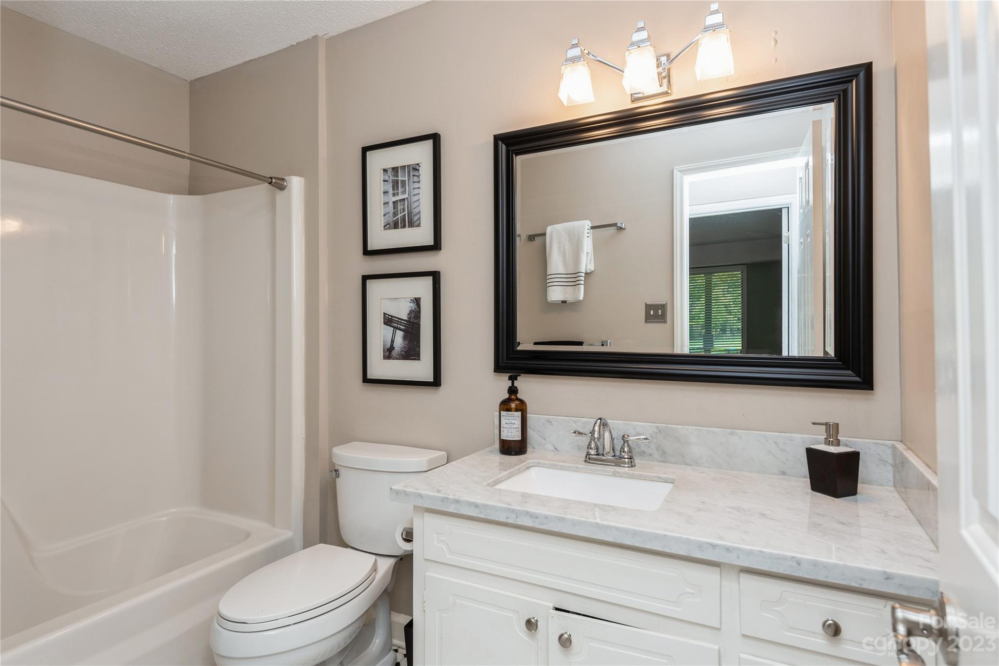 92 Fairway Ridge, Unit 8 Clover, SC 29710 - Photo 27 of 34 a bathroom with a granite countertop sink mirror vanity and toilet