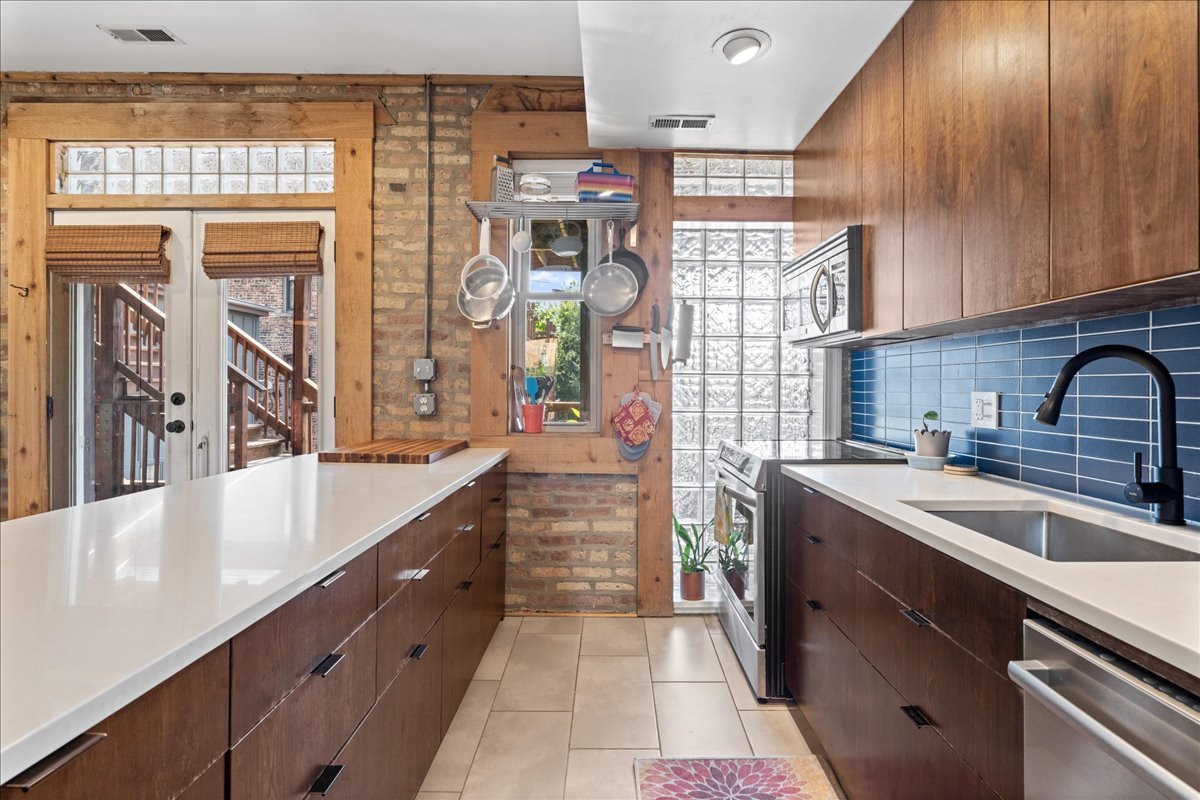 3107 West George Street, Unit 2 Chicago, IL 60618 - Photo 7 of 17 a kitchen with a sink cabinets and window