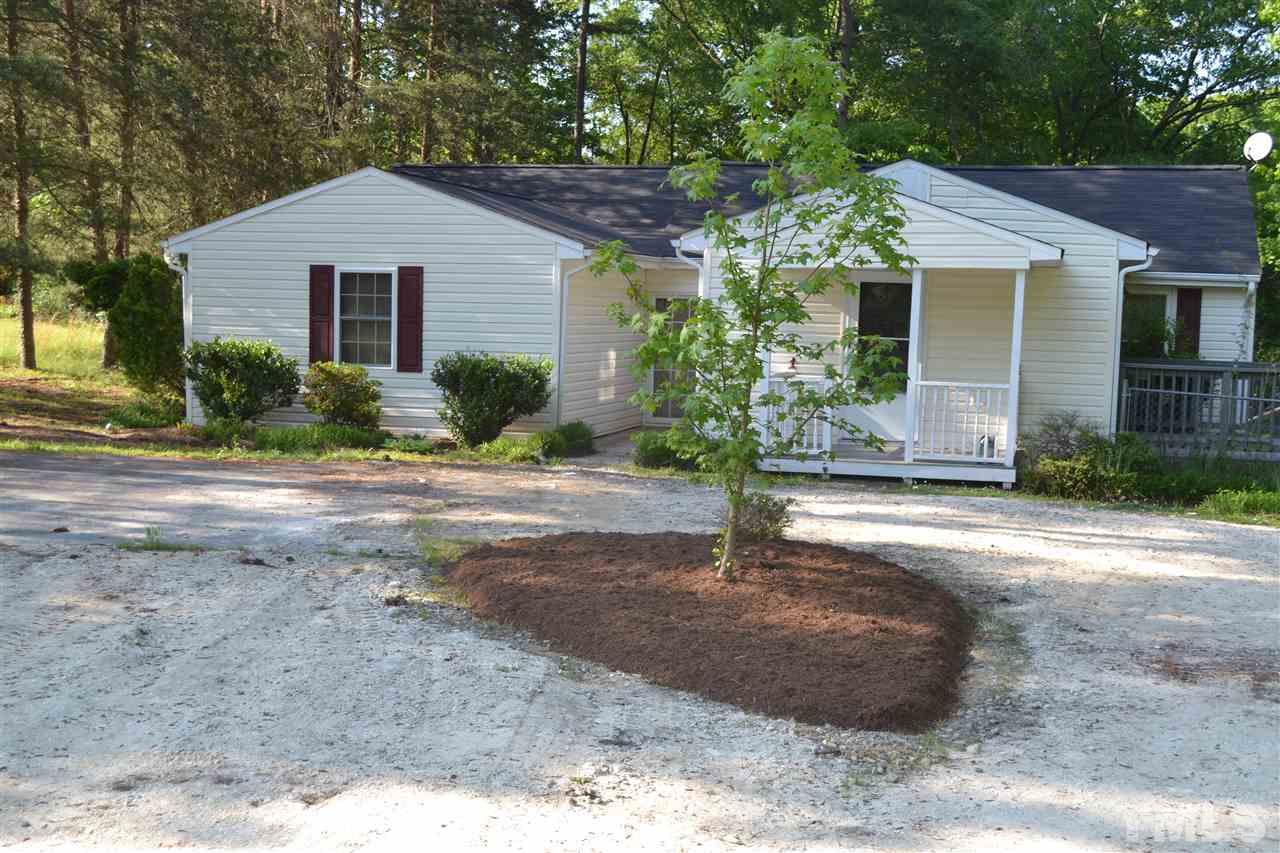 4623 Bragg Road Durham, NC 27704 - Photo 1 of 25 a front view of a house with a yard and potted plants