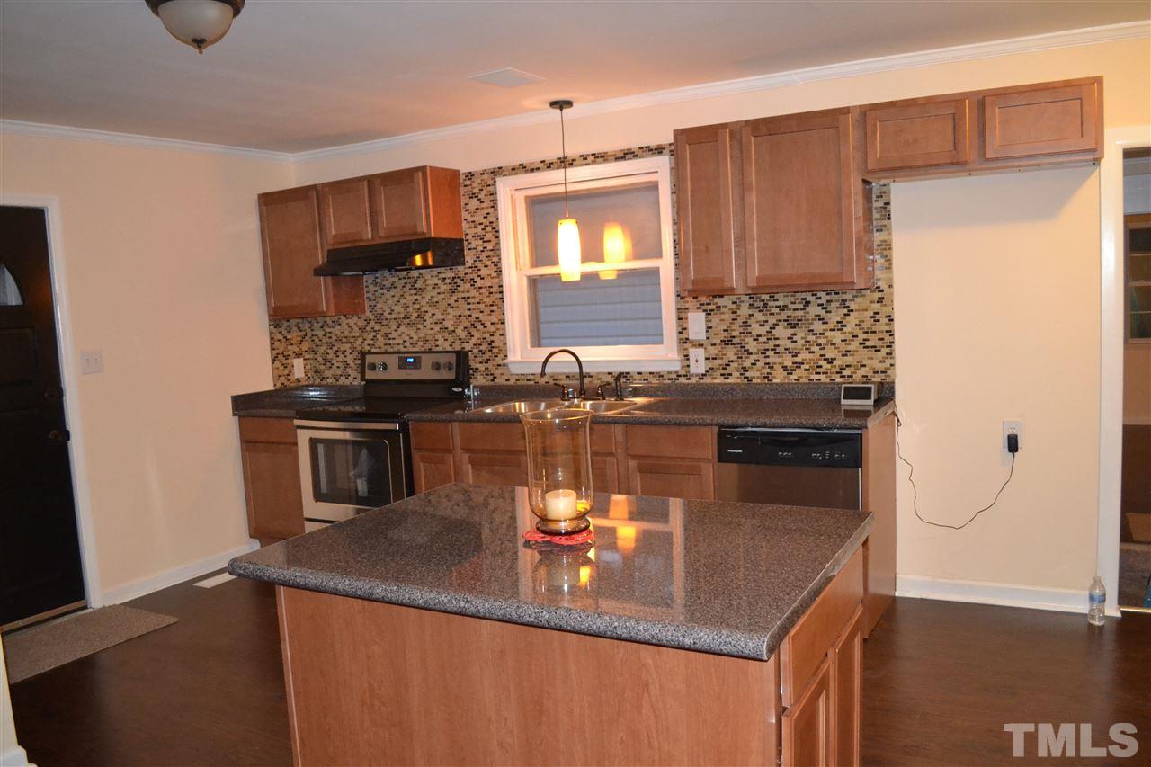 4623 Bragg Road Durham, NC 27704 - Photo 3 of 25 a kitchen with granite countertop a stove and a sink