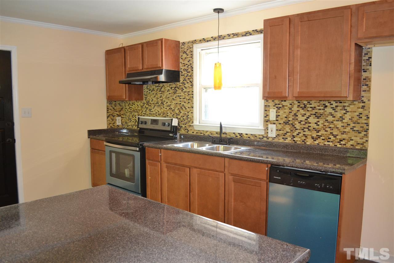 4623 Bragg Road Durham, NC 27704 - Photo 4 of 25 a kitchen with granite countertop a sink stainless steel appliances and cabinets