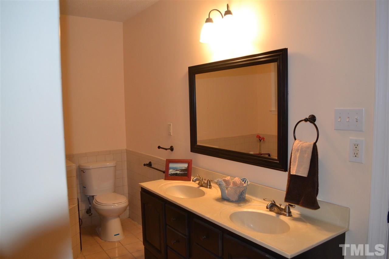 4623 Bragg Road Durham, NC 27704 - Photo 10 of 25 a bathroom with a sink vanity mirror and toilet