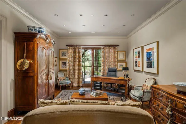 a bedroom with a bed a bookshelf and a large window