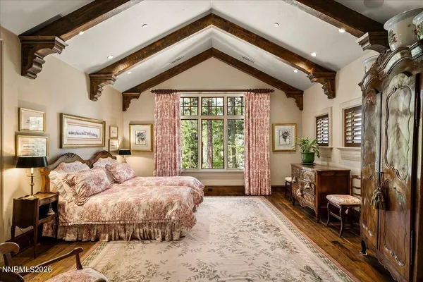 a view of a white house with a large tree