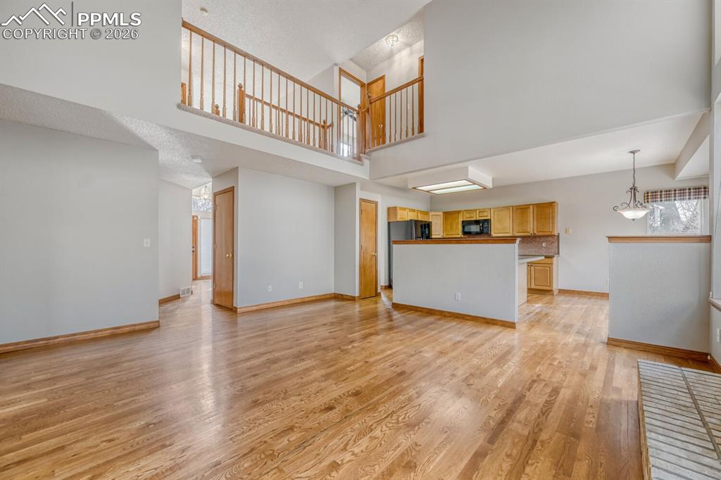 7215 Native Circle Colorado Springs, CO 80919 - Photo 11 of 30 a view of a big room with wooden floor and kitchen
