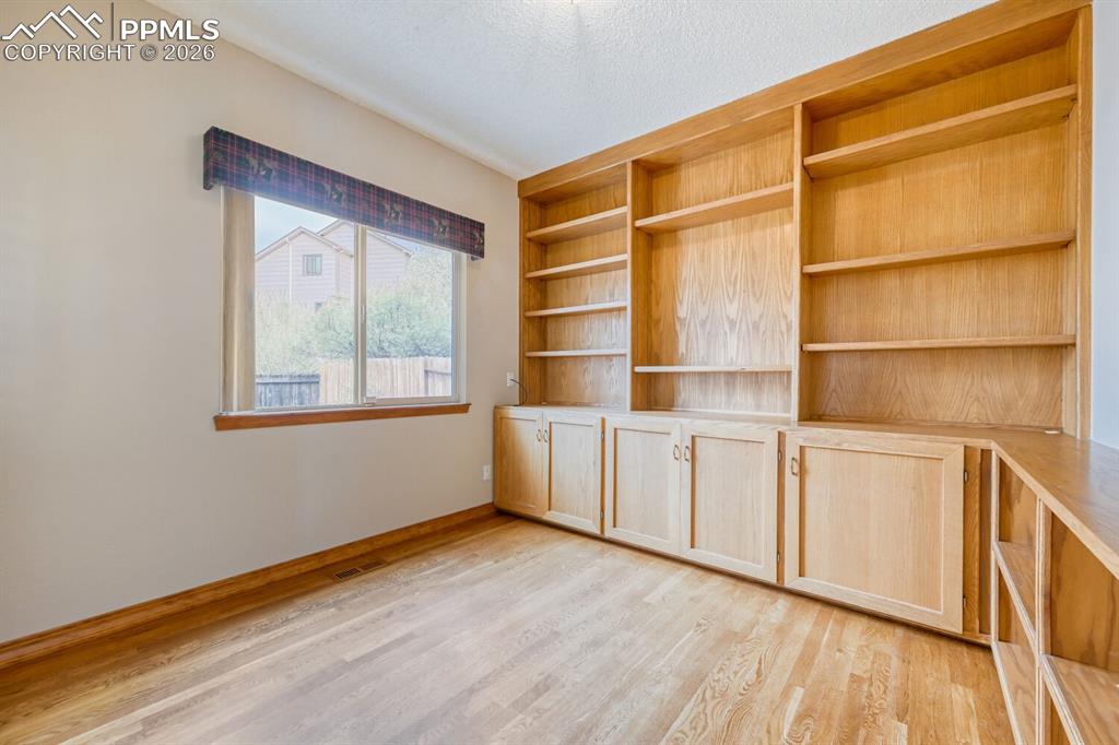 7215 Native Circle Colorado Springs, CO 80919 - Photo 19 of 30 a big room with wooden floors and cabinet