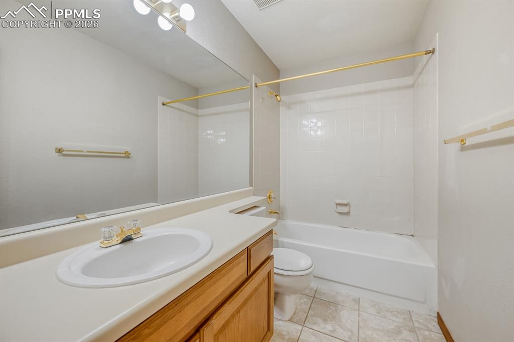 7215 Native Circle Colorado Springs, CO 80919 - Photo 27 of 30 a bathroom with a granite countertop sink a toilet and shower