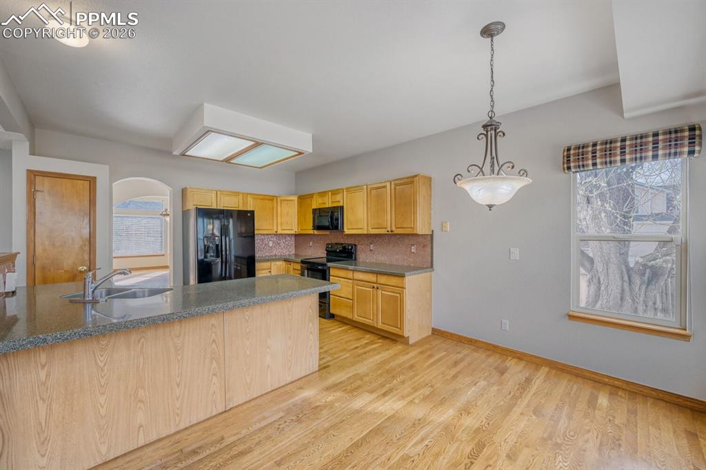 7215 Native Circle Colorado Springs, CO 80919 - Photo 5 of 30 a large kitchen with kitchen island a counter space a sink and appliances