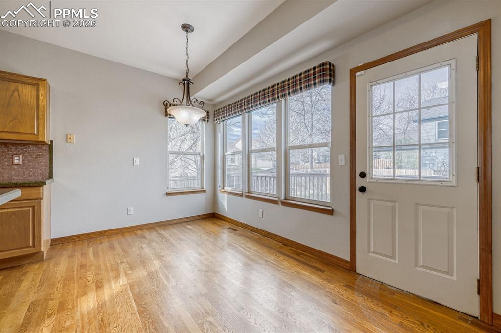 7215 Native Circle Colorado Springs, CO 80919 - Photo 7 of 30 a view of an empty room with a window and wooden floor
