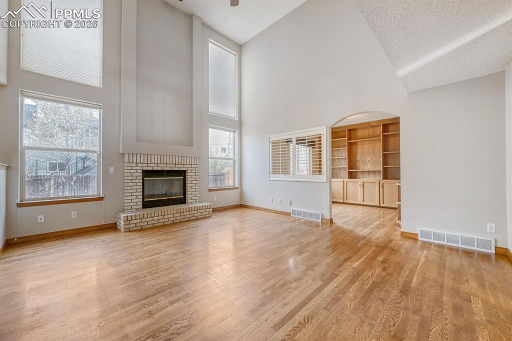 7215 Native Circle Colorado Springs, CO 80919 - Photo 9 of 30 wooden floor fireplace and windows in an empty room