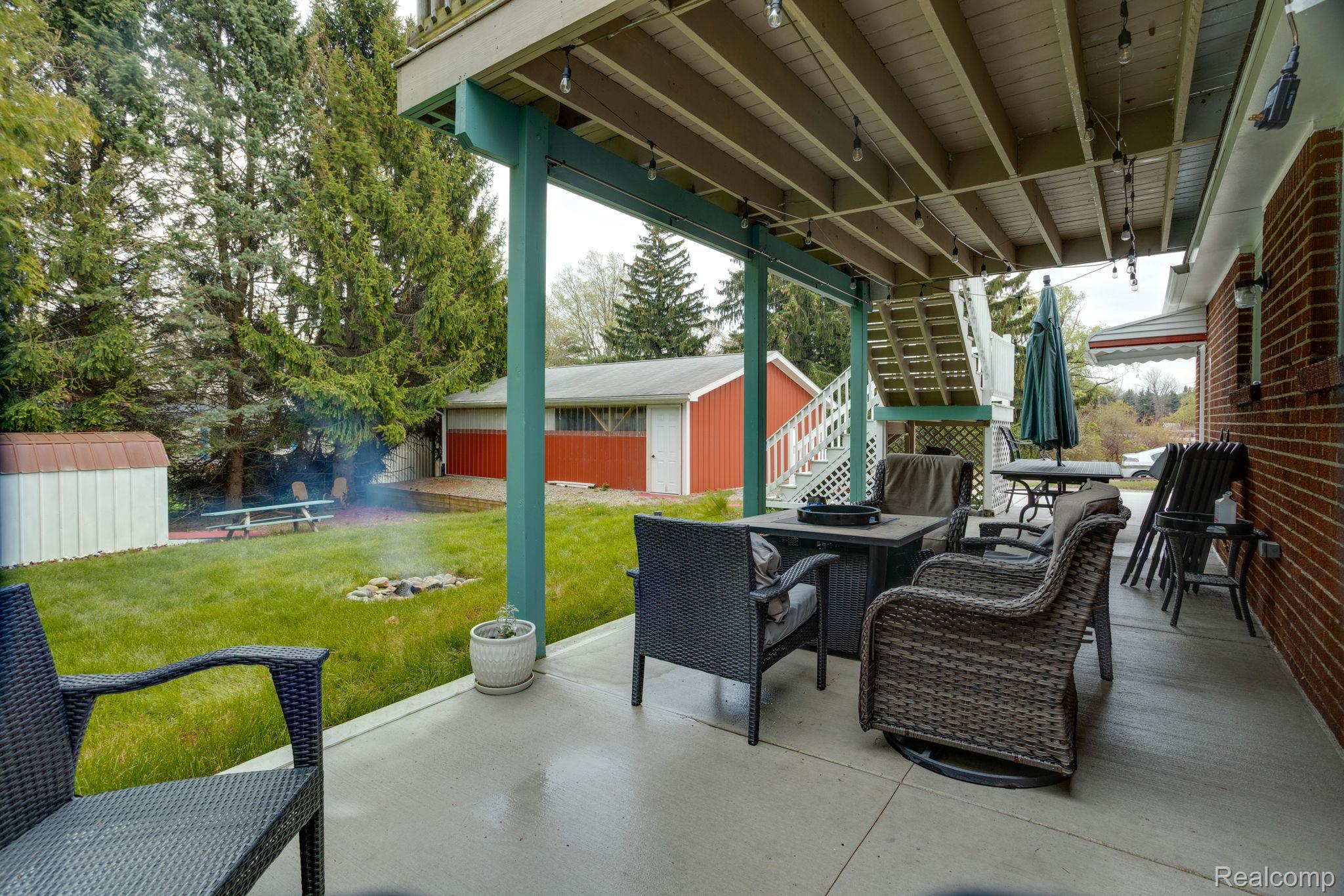 2400 North Lakeshore Road Carsonville, MI 48419 - Photo 4 of 33 View of patio with outdoor dining space, a storage shed, and an outdoor fire pit