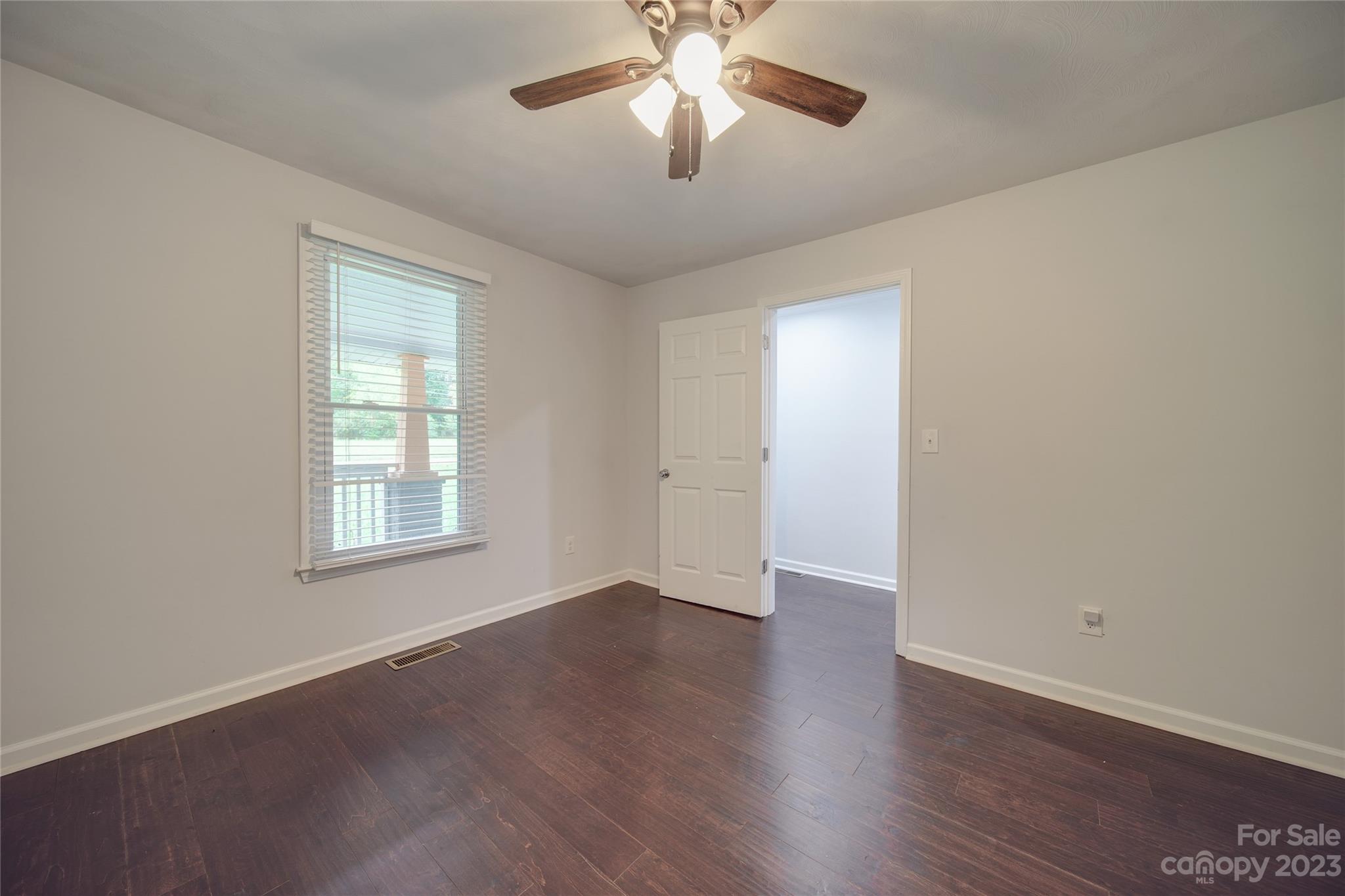 570 Crescent Road Rockwell, NC 28138 - Photo 15 of 28 an empty room with wooden floor chandelier fan and windows