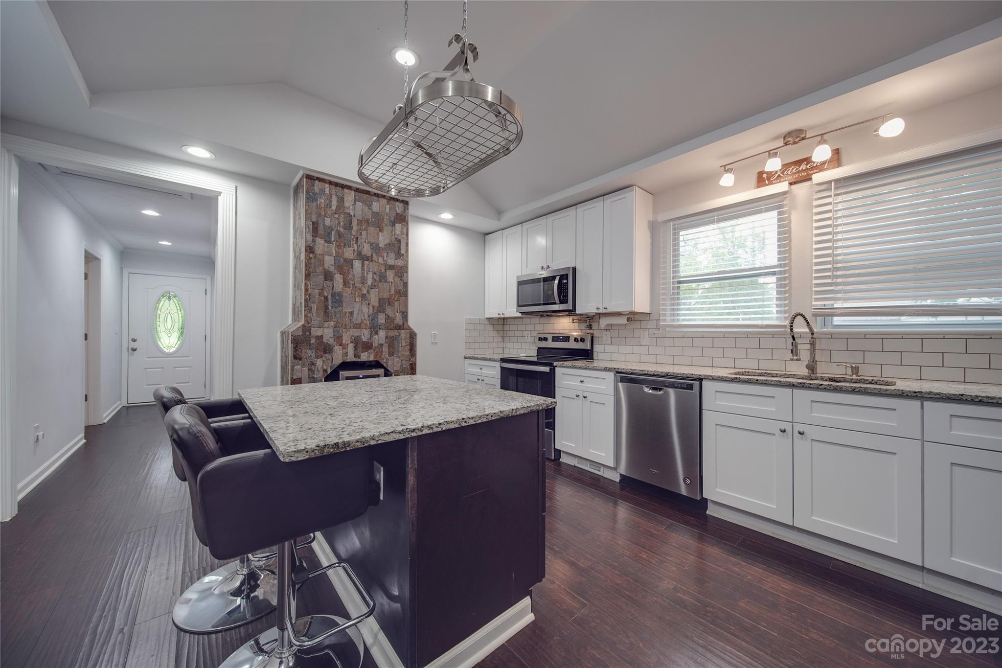 570 Crescent Road Rockwell, NC 28138 - Photo 6 of 28 a open kitchen with granite countertop a stove a sink a dining table and chairs