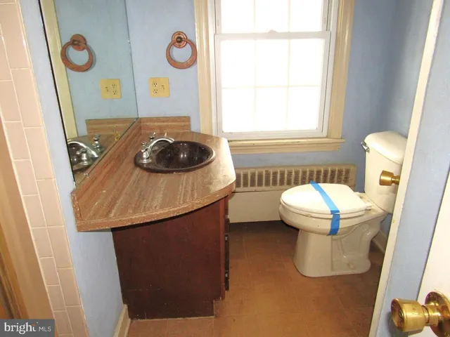 a bathroom with a sink a toilet and a window