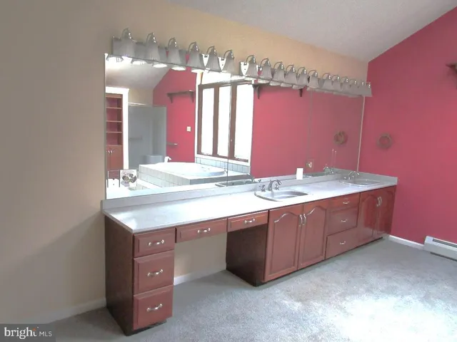 a bathroom with a granite countertop double vanity sink and a large mirror