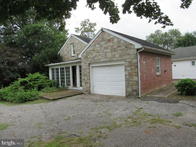 a front view of house with yard and trees all around