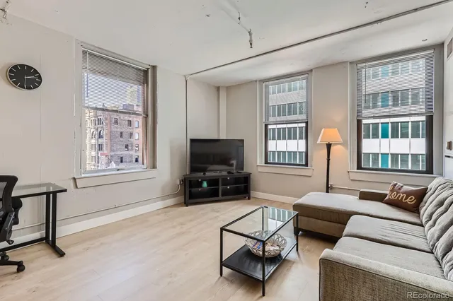 a living room with furniture a flat screen tv and a window